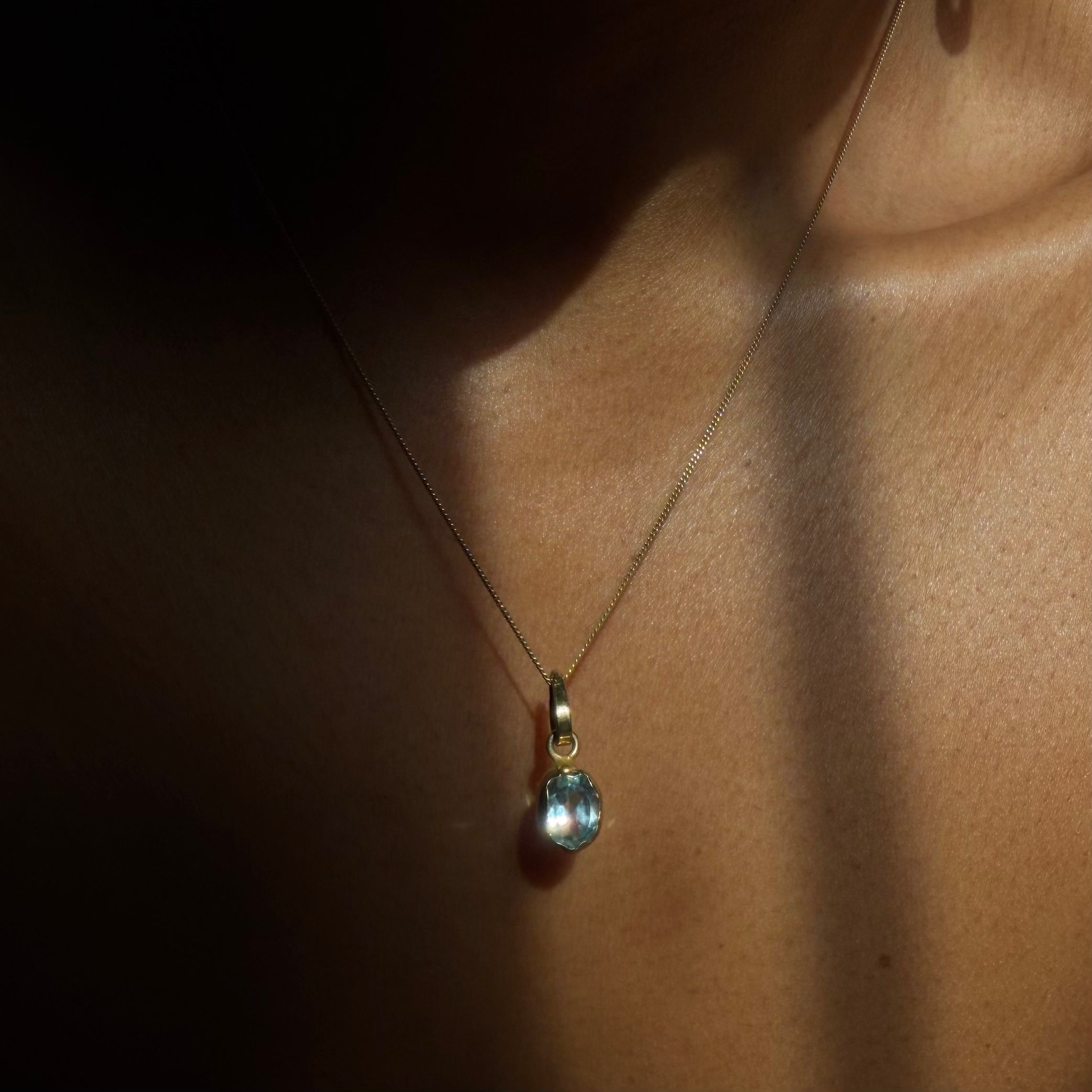 blue topaz solitaire gold necklace on wearing