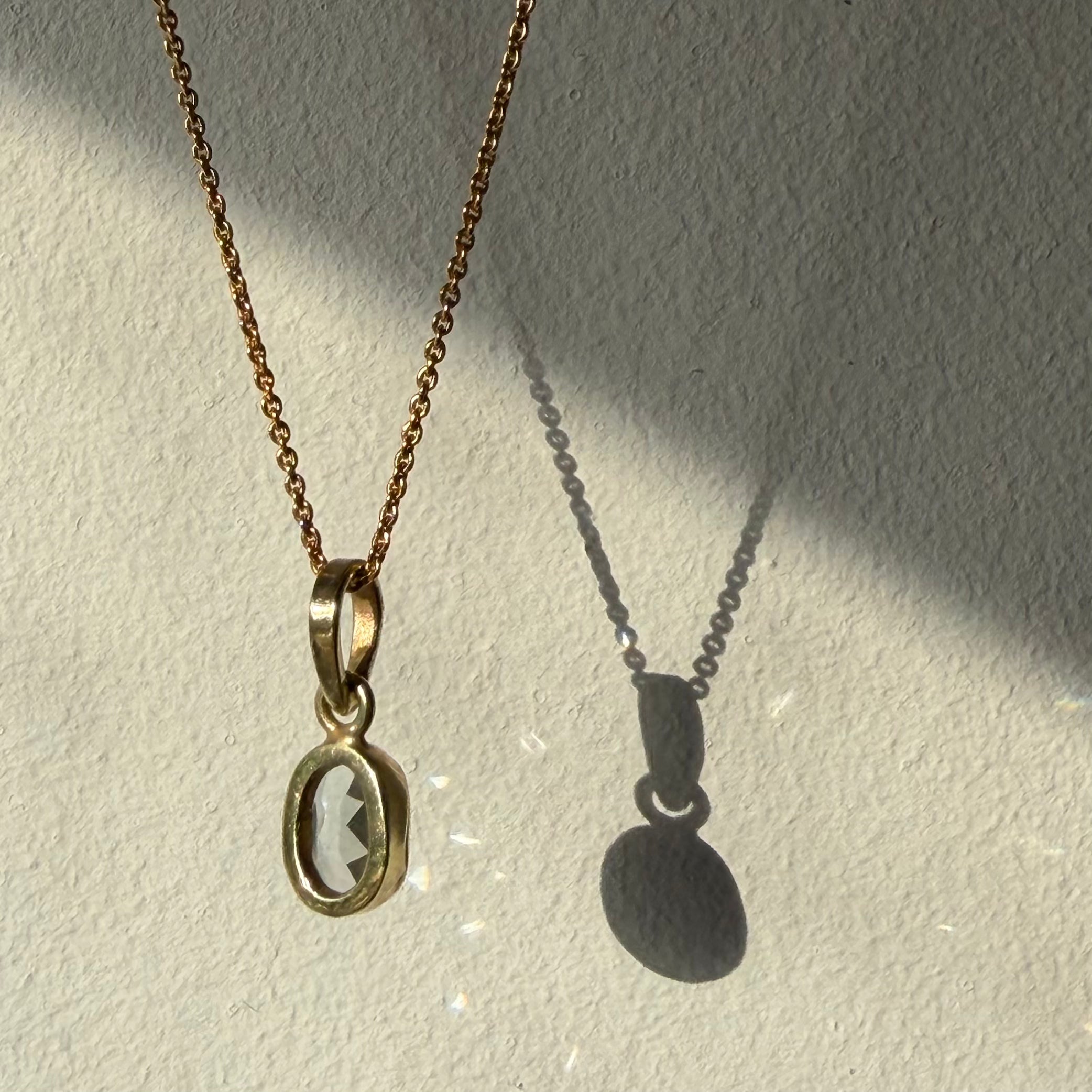 open back design of blue topaz gold pendant