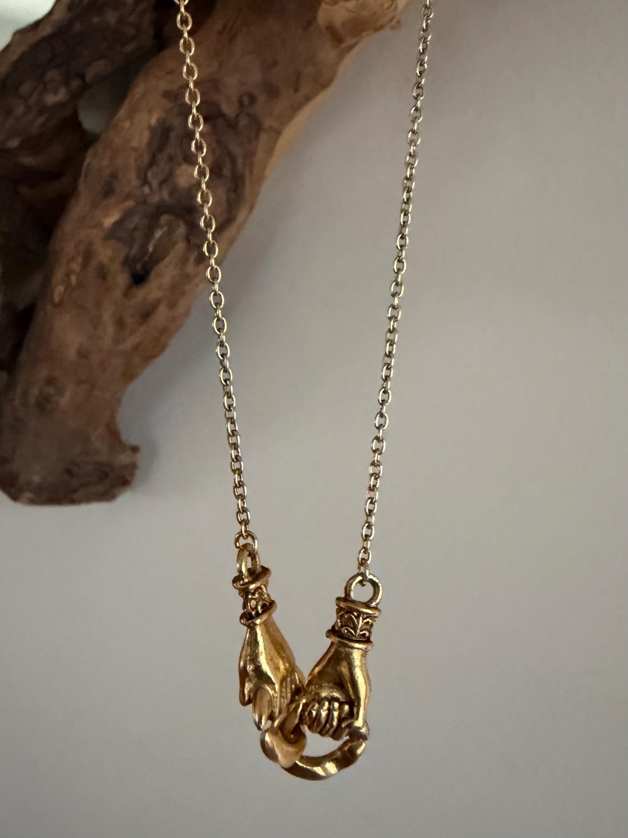 interlocking connection gold hands necklace