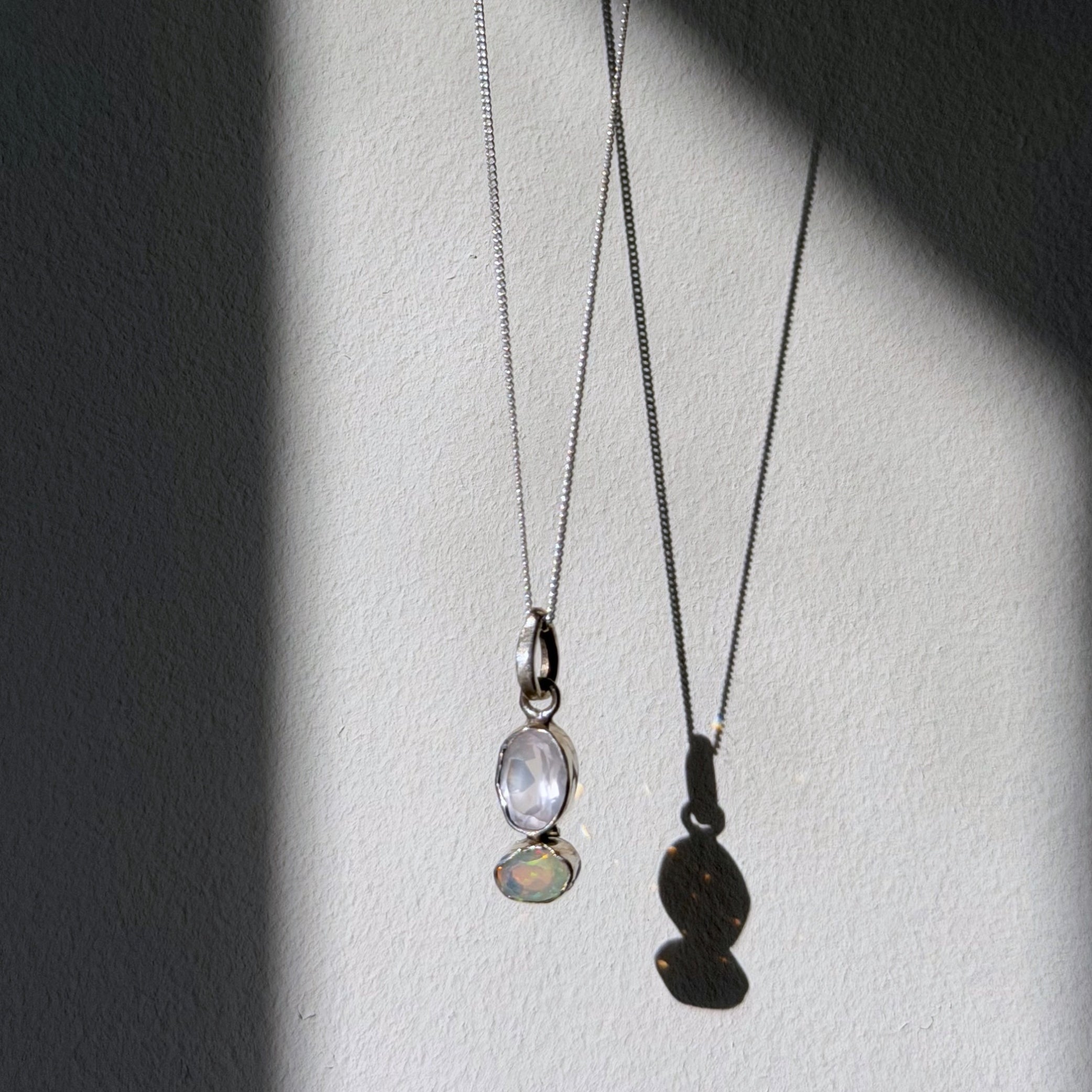 rose quartz and opal sterling silver pendant hanging in natural light