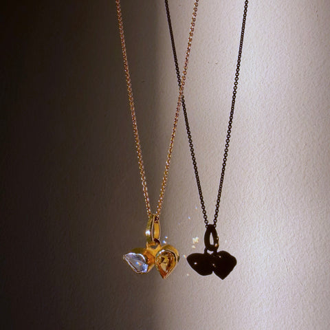 blue topaz and citrine toi et moi gold necklace hanging in sunlight