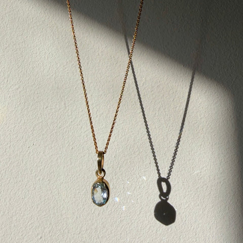 blue topaz solitaire gold pendant hanging in dalying