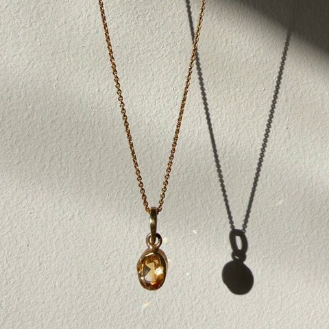 citrine solitaire gold pendant hanging in daylight