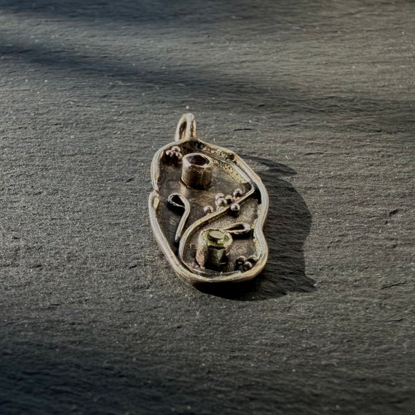 Side profile of sterling silver yin yang pendant showing handcrafted detail and gemstone settings