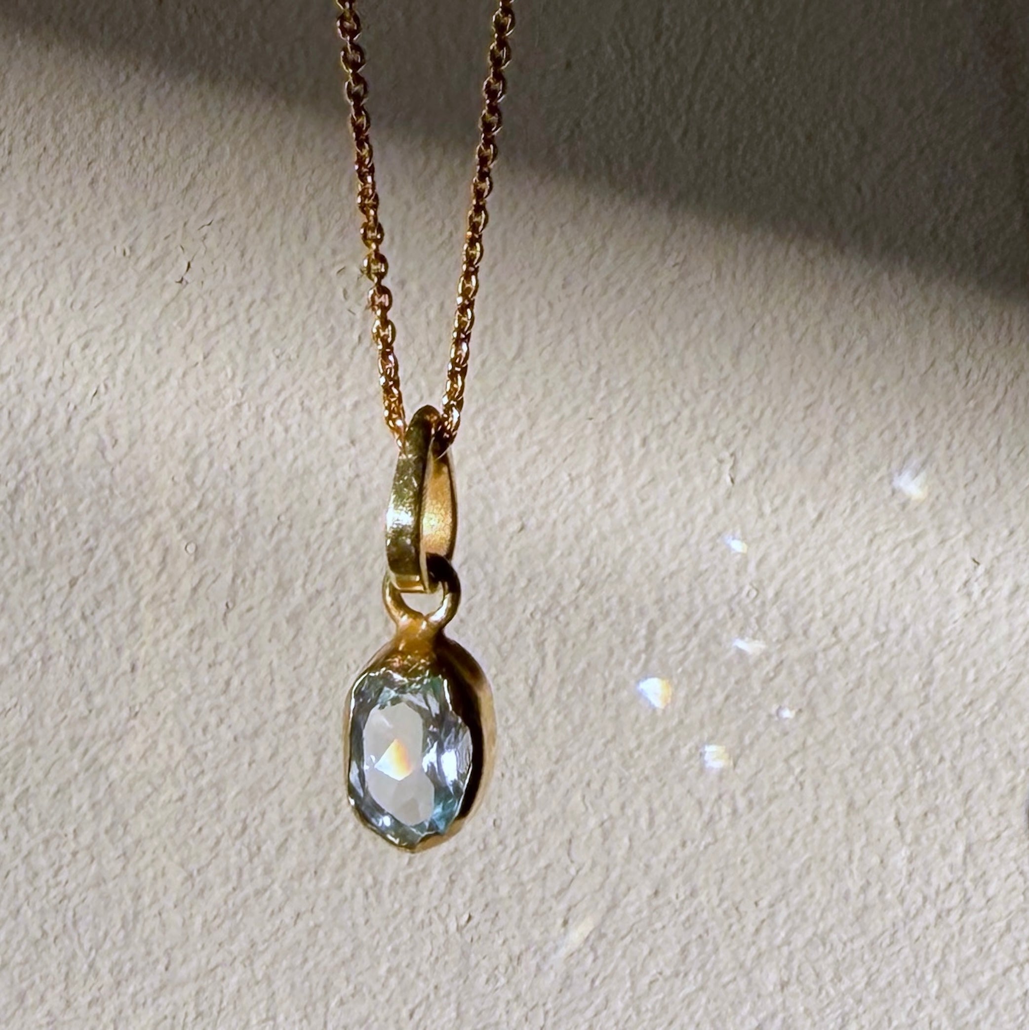 blue topaz gold pendant up close