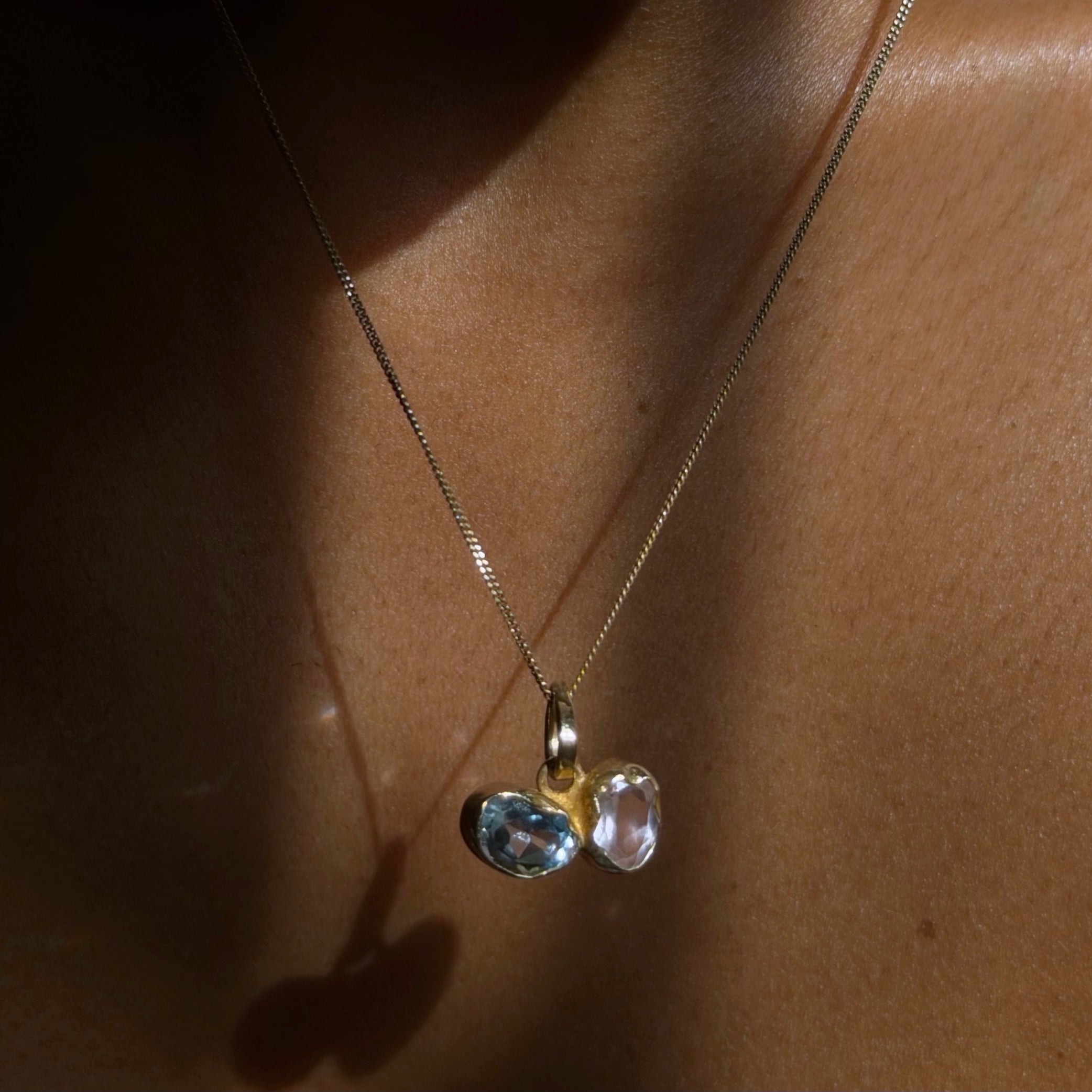 Blue topaz and rose quartz toi et moi pendant in gold dipped sterling silver worn on skin