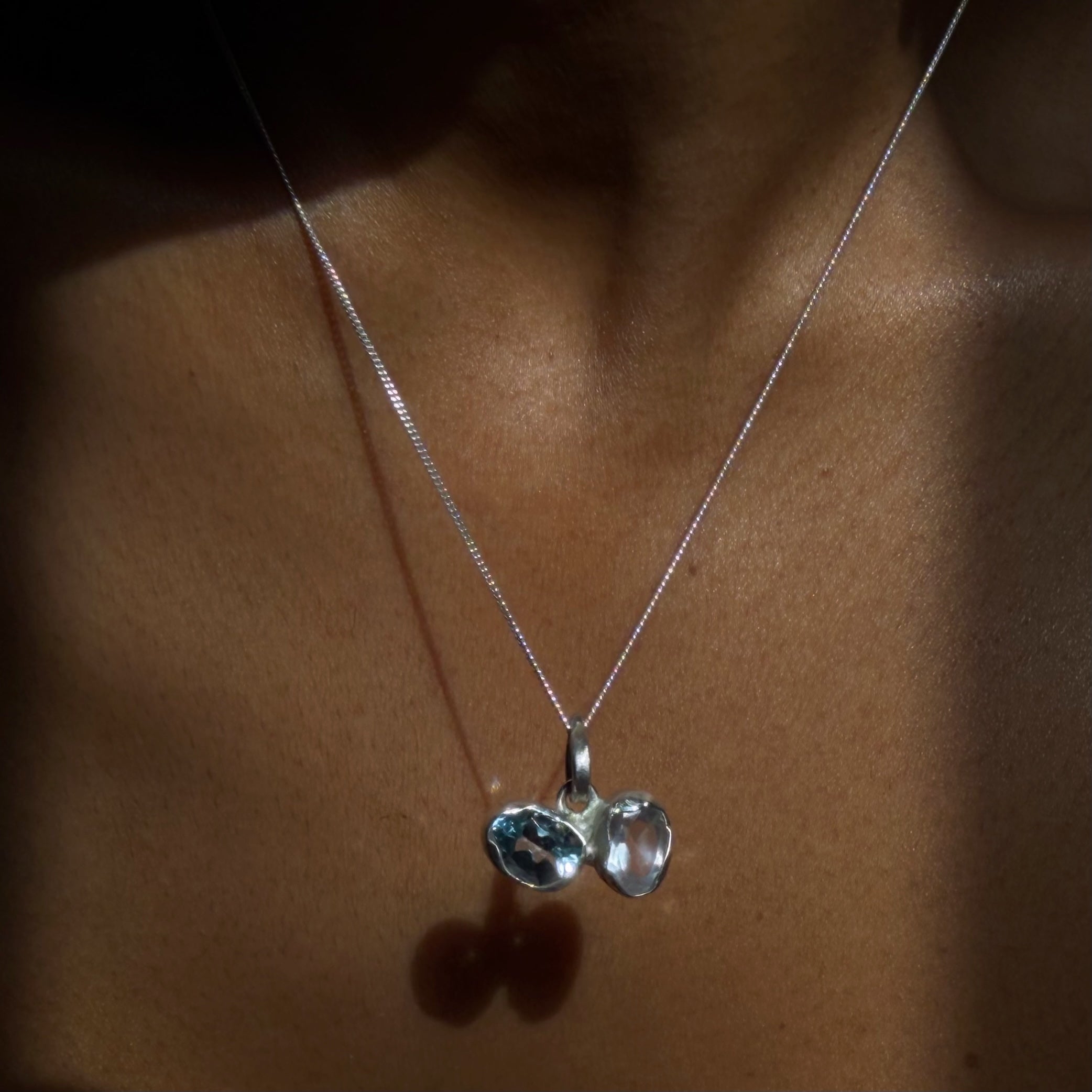 Blue topaz and rose quartz toi et moi pendant in sterling silver worn on skin