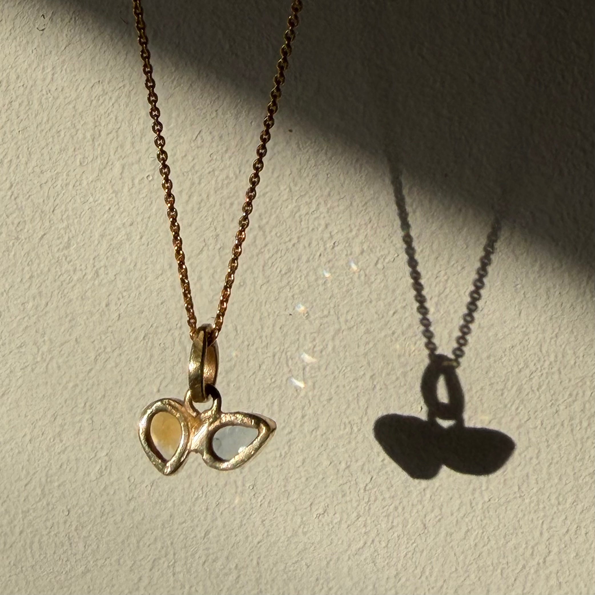 open back design of blue topaz and citrine toi et moi gold pendant