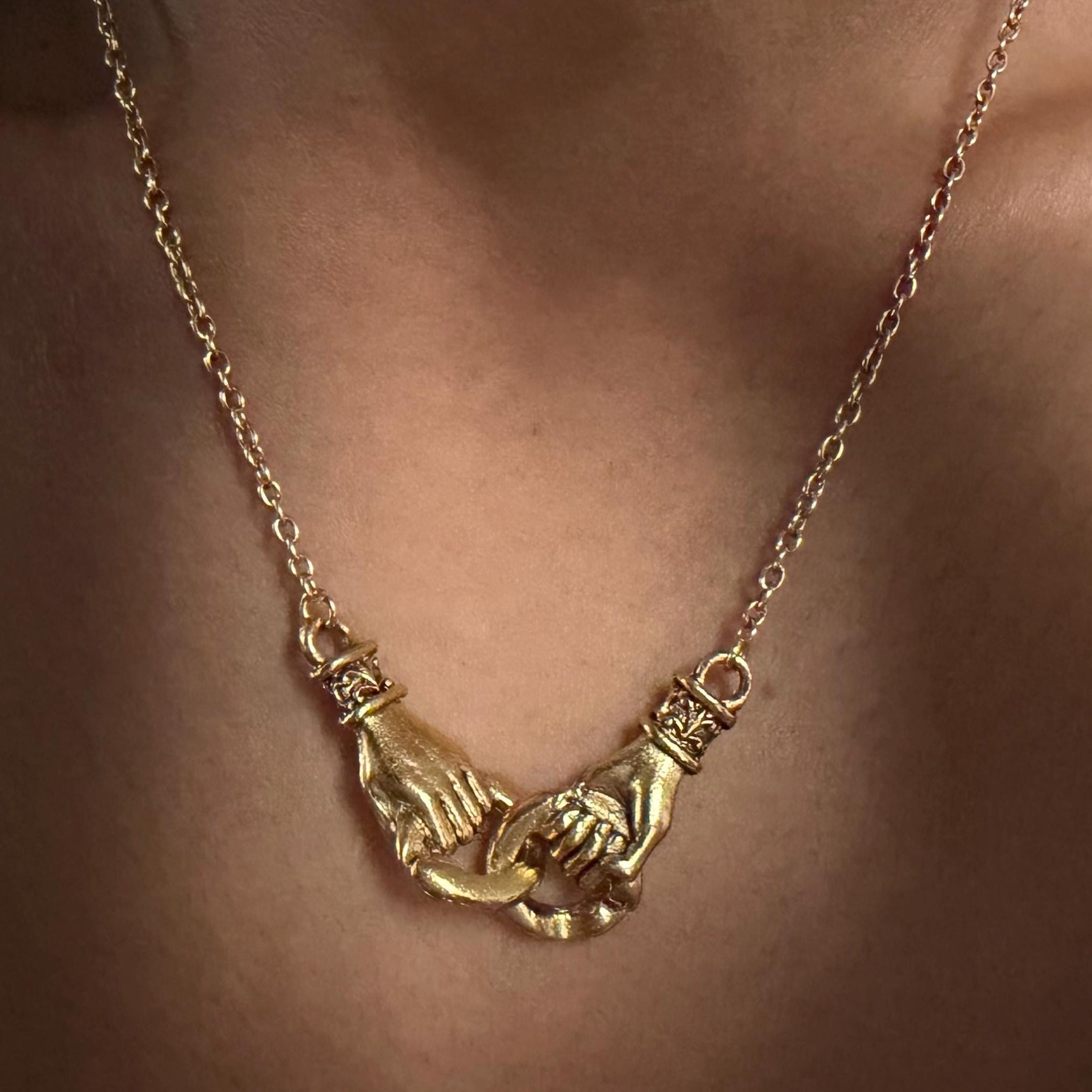 gold interlocking hands necklace