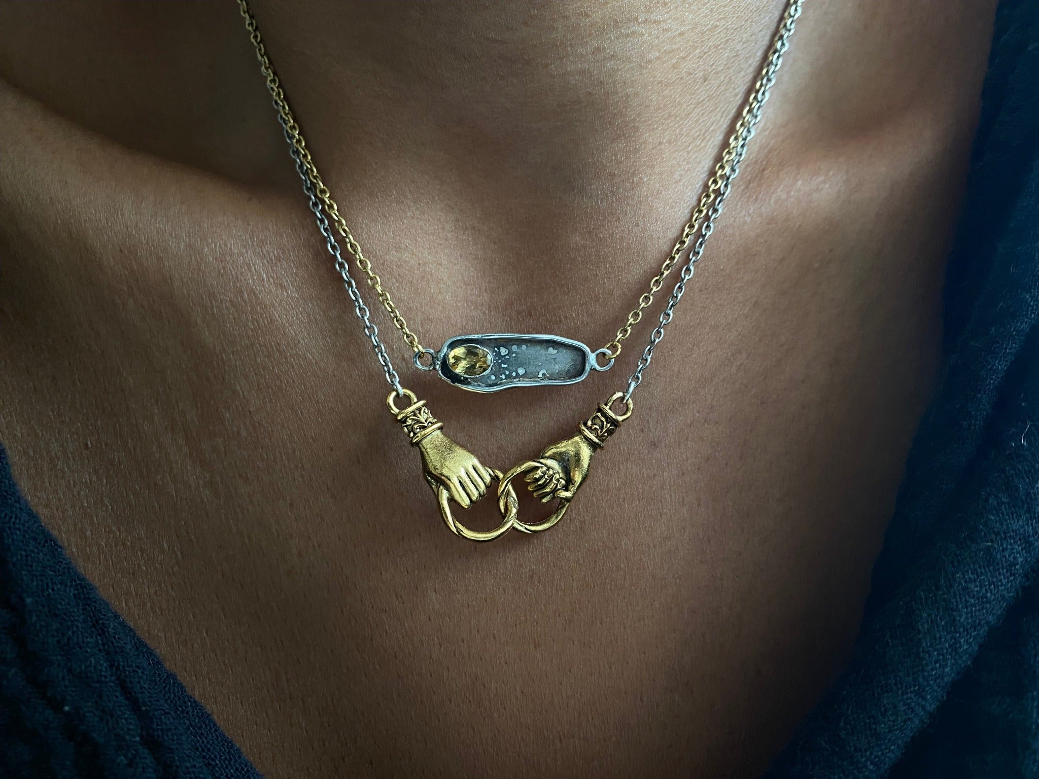 interlocking hands mixed metal necklace