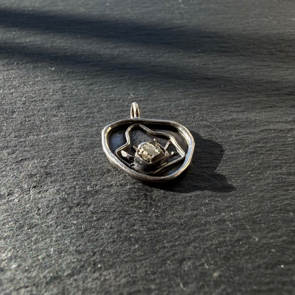 Side view of sterling silver evil eye shell pendant with pyrite gemstone