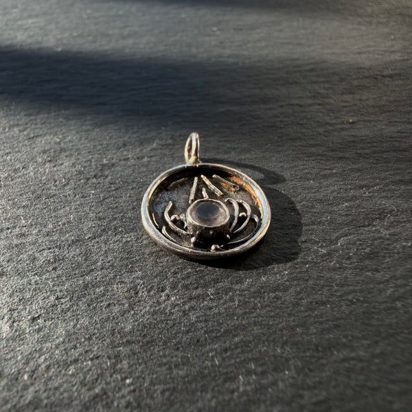 Side profile of sterling silver lotus pendant with rose quartz showing raised detailing