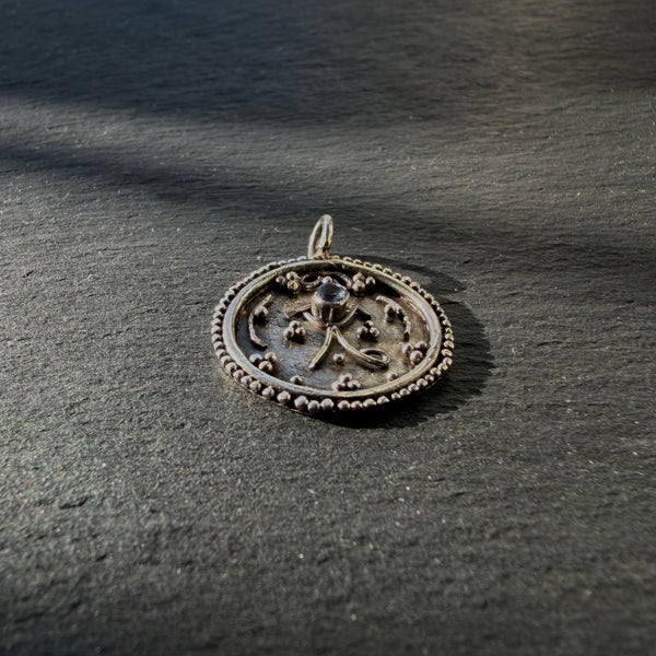 Side profile of sterling silver Eye of Horus talisman pendant with tanzanite